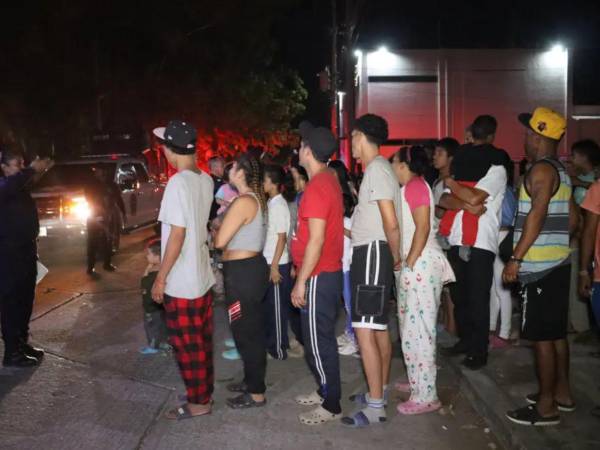 Migrantes se preparan para recibir comida este martes en campamentos improvisados en el municipio de Tapachula en Chiapas.