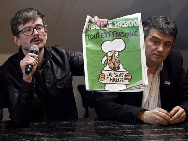 El caricaturista Renald Luzier sostiene un ejemplar del semanario francés satírico Charlie Hebdo.