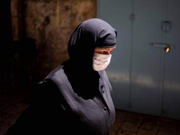 Una monja con mascarilla se dirige a la Iglesia del Santo Sepulcro, Jerusalén, sábado 18 de abril de 2020. Unos pocos clérigos celebraron allí la tradicional festividad ortodoxa de la Luz Sagrada, parte de la Pascua ortodoxa. .(AP Foto/Ariel Schalit)