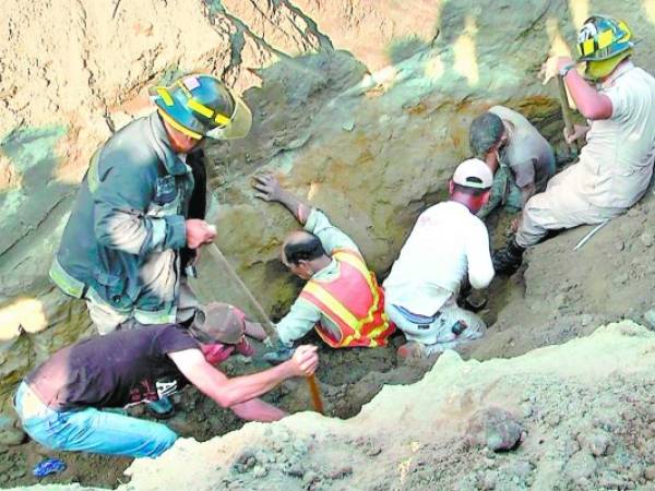 Compañeros de trabajo rescatan a los tres obreros soterrados.