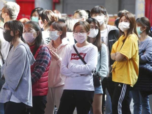 People wear face masks to protect against the spread of the coronavirus in Taipei, Taiwan, Wednesday, Feb. 26, 2020. (AP Photo/Chiang Ying-ying)