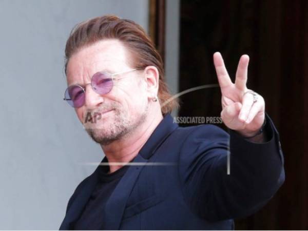 En esta imagen de archivo, tomada el 24 de julio de 2017, el cantante de U2, Bono, hace el signo de la paz con la manos a su llegada a una reunión en el Palacio del Elíseo, en París, Francia.