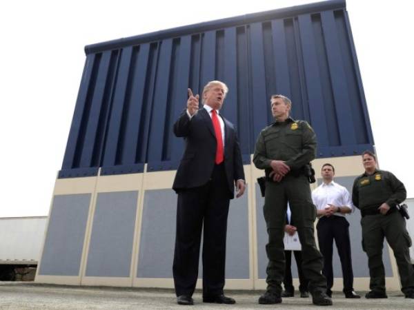 En esta fotografía del 13 de marzo de 2018, el presidente Donald Trump habla durante una revisión de los prototipos para el muro fronterizo en San Diego, mientras Rodney Scott, jefe del sector de San Diego de la Patrulla Fronteriza, lo escucha. (AP Foto/Evan Vucci, Archivo)