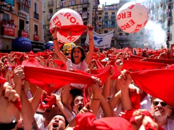 (FILES) In this file photo taken on July 06, 2019 revellers hold red scarves during the 'Chupinazo' (start rocket) to mark the kickoff at noon sharp of the San Fermin Festival, in front of the Town Hall of Pamplona, northern Spain. - Spain's best-known bull running festival in the northern town of Pamplona, held annually between July 6 and 14, has ben cancelled this year due to the coronavirus pandemic, city hall said on April 21, 2020. (Photo by ANDER GILLENEA / AFP)