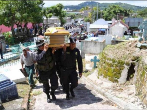 Elementos de la Policía Civil de El Salvador cargan a uno de sus compañeros asesinado por pandilleros.