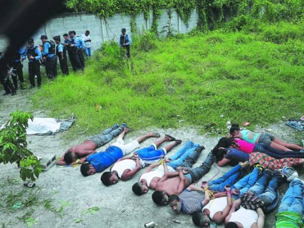 Tras ser capturados, los 12 pandilleros fueron colocados boca abajo por la Policía, junto al cuerpo del ayudante de bus asesinado, fotos: EL HERALDO / Noticias de Honduras / Sucesos de Honduras.