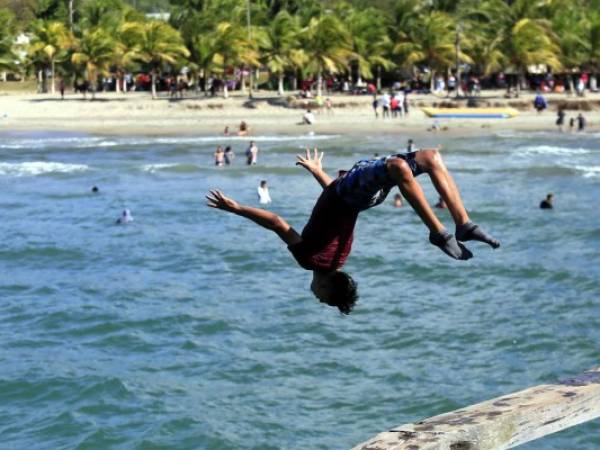 Los turistas y visitantes locales de la ciudad costera aprovechan la altura del muelle para hacer clavados. Foto: EL HERALDO/Marvin Salgado