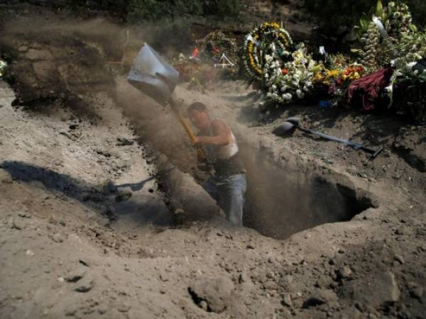 Un trabajador cava una tumba en el cementerio municipal de Valle de Chalco, en las afueras de la Ciudad de México, construido para dar cabida al creciente número de muertos por la pandemia de coronavirus, el jueves 21 de mayo de 2020. (AP Foto/Marco Ugarte)