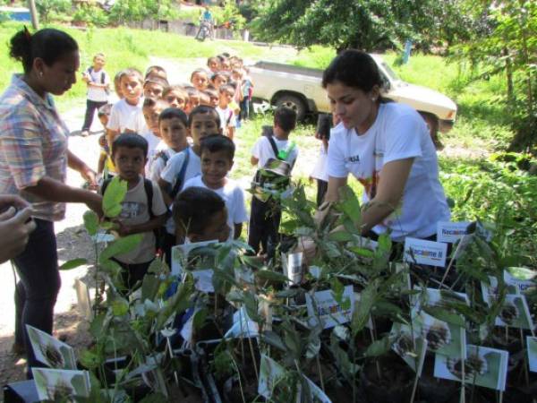 Los niños del Centro de Educación Básica José Cecilio del Valle al recibir un árbol.