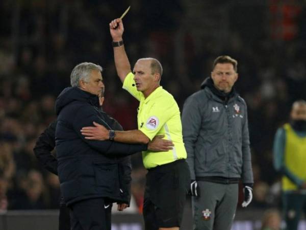 Southampton's Austrian manager Ralph Hasenhuttl (R) looks on a English referee Mike Dean shows Tottenham Hotspur's Portuguese head coach Jose Mourinho (L) a yellow card during the English Premier League football match between Southampton and Tottenham at St Mary's Stadium in Southampton, southern England on January 1, 2020. (Photo by Adrian DENNIS / AFP) / RESTRICTED TO EDITORIAL USE. No use with unauthorized audio, video, data, fixture lists, club/league logos or 'live' services. Online in-match use limited to 120 images. An additional 40 images may be used in extra time. No video emulation. Social media in-match use limited to 120 images. An additional 40 images may be used in extra time. No use in betting publications, games or single club/league/player publications. /