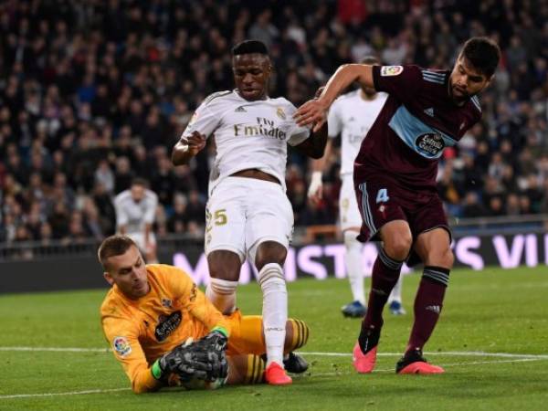 Madrid: el delantero brasileño del Real Madrid Vinicius Junior (C) desafía al portero español del Celta Vigo Rubén Blanco Veiga (abajo) durante el partido de fútbol de la liga española entre el Real Madrid CF y el RC Celta de Vigo en el estadio Santiago Bernabeu de Madrid el 16 de febrero de 2020. / AFP / PIERRE-PHILIPPE MARCOU