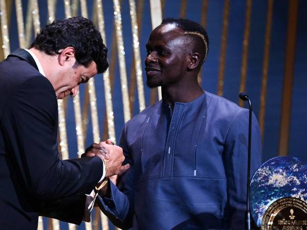 El delantero senegalés del Bayern, Sadio Mane (centro), recibe el Trofeo Sócrates al jugador más involucrado en proyectos sociales y benéficos.