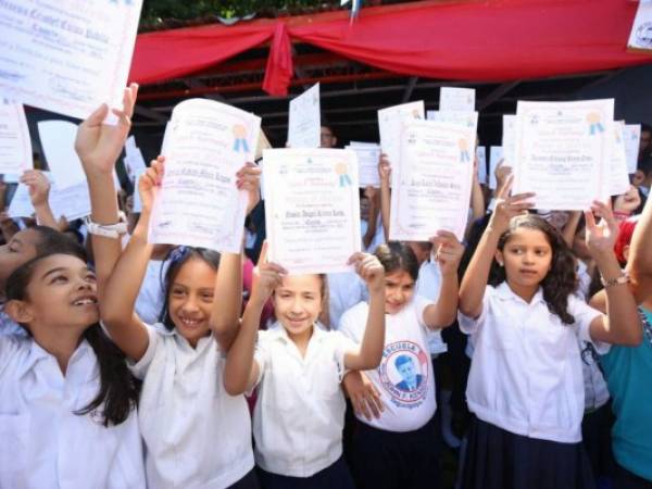 Alumnos de la Escuela John F. Kennedy muestran sus certificados durante la clausura en Tegucigalpa.