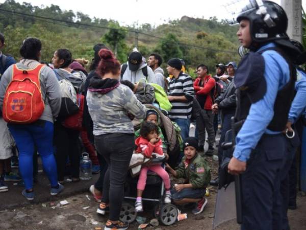 Cargando niños pequeños en brazos o en carruajes, los hondureños ingresaron la noche del martes en suelo guatemalteco tras romper el cerco policial en su país. Foto / AFP