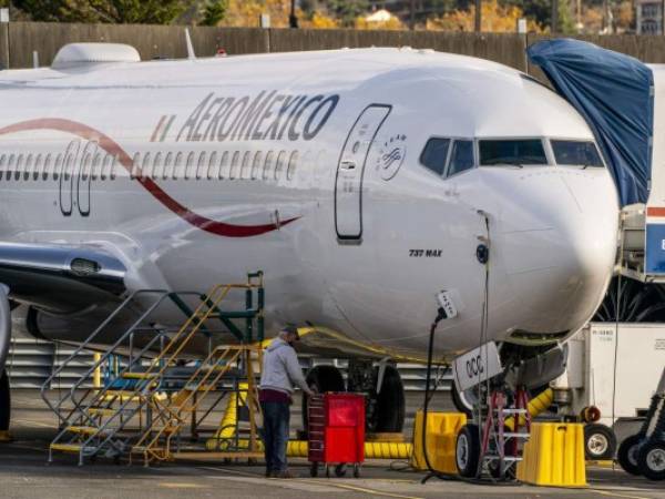 Un trabajador se para debajo de un avión Boeing 737 Max mientras está estacionado en las instalaciones de producción de Renton de la compañía el 13 de noviembre de 2020 en Renton, Washington, Estados Unidos. Foto: AFP