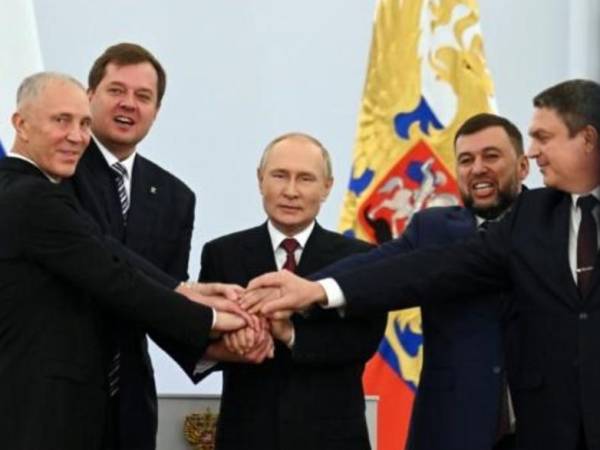 El presidente Vladimir Putin (centro) junta sus manos con las de los dirigentes de las cuatro regiones de Ucrania tras firmar los tratados de anexión a Rusia, el 30 de septiembre de 2022 en Moscú.