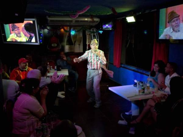 Cuban actor Luis Silva whose stage name is 'Panfilo' performs in front of the public in Havana, Cuba, Monday, Dec. 8, 2014. Silva is part of a new wave of Cuban comedians that is drawing big broadcast audiences and huge live crowds, using biting humor to take on corruption, shortages, government inefficiency and other everyday problems in a country where the government tolerates little dissent. (AP Photo/Desmond Boylan)