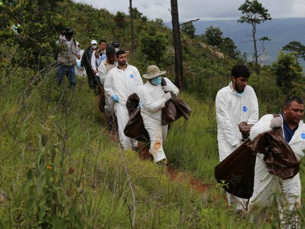 Cuando los cadáveres son enterrados en zonas montañosas, las autoridades deben -en muchos casos- cargar los cuerpos hasta donde están los vehículos.