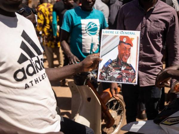 Un hombre sostiene una imagen del depuesto presidente de Burkina Faso.