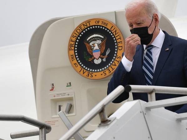 El presidente de Estados Unidos, Joe Biden, se toca la mascarilla al bajar del Air Force One a su llegada al aeropuerto regional de Hagerstown, Maryland.