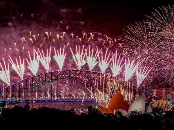 Los fuegos artificiales explotan sobre el Puente del Puerto de Sídney y la Ópera de Sídney durante las celebraciones de Nochevieja en Sídney. Multitudes jubilosas despedirán el domingo el año más caluroso jamás registrado y cerrarán 12 turbulentos meses marcados por chatbots inteligentes, crisis climáticas y guerras desgarradoras en Gaza y Ucrania.