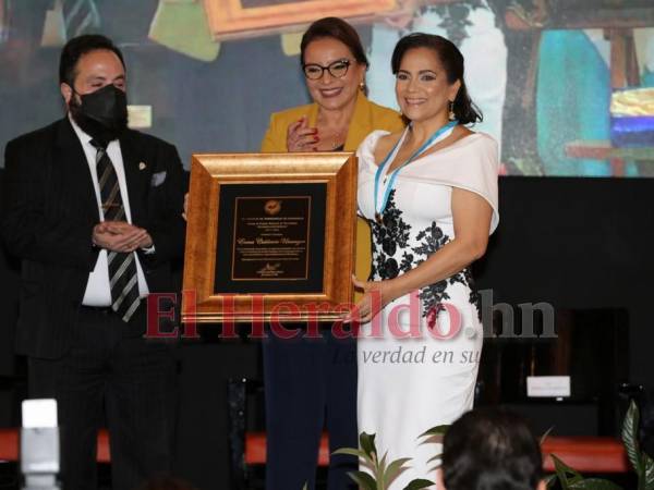 La periodista Enma Calderón mientras recibe su premio Álvaro Contreras al lado de la presidenta Xiomara Castro y Luis Redondo, presidente del CN.