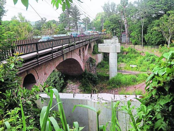 El contraste entre la piedra utilizada en el siglo XX y el concreto del siglo XXI se visualizan mientras el tráfico vehicular se mantiene en el puente calificado como “embudo”.