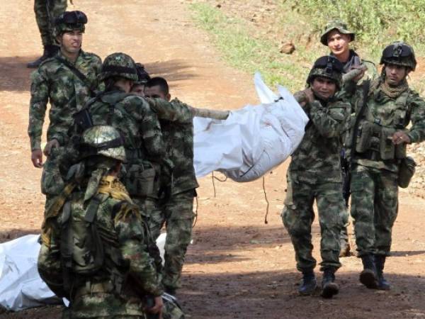 Militares colombianos cargan los cuerpos de sus compañeros caídos a manos de guerrilleros.