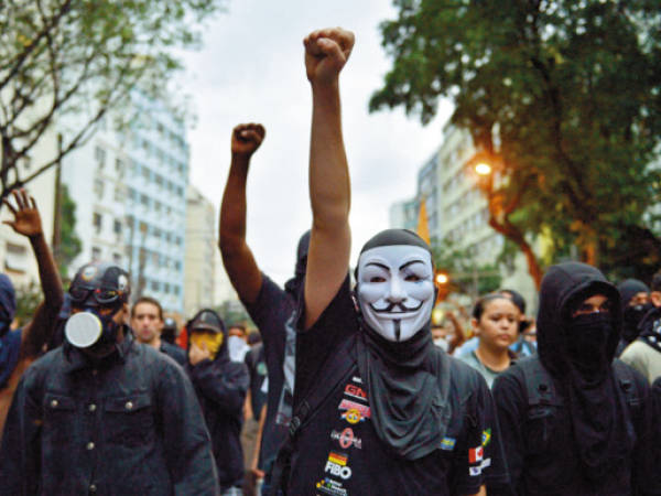 TOPSHOTSHardline demonstrators wear masks during a protest in a street near the Maracana stadium of Rio de Janeiro on June 30, 2013, a few hours before the final of the Fifa Confederations Cup football tournament between Brazil and Spain. More than 11,000 police and troops were mobilised in the city to guarantee security for 78,000 fans at the venue as the curtain falls on a competition that has been beset by social unrest with more than 1.5 million people taking to the streets across the giant nation in the past two weeks. AFP PHOTO / YASUYOSHI CHIBA