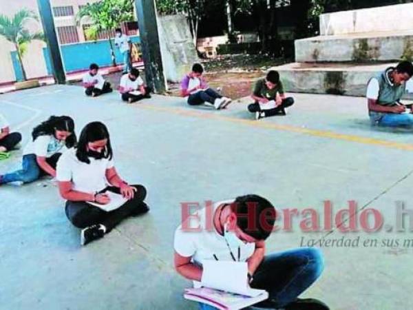 Los alumnos permanecen sentados en el piso cuando reciben clases en el gimnasio.