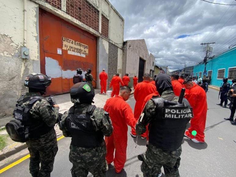 De overol naranja y grilletes, reclusos borran “placazos” de maras y pandillas en la capital