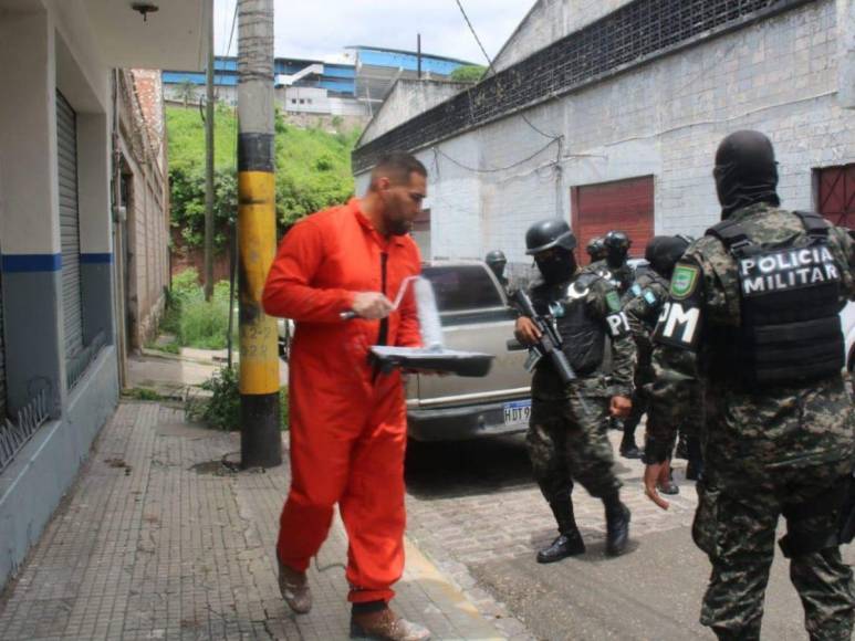 De overol naranja y grilletes, reclusos borran “placazos” de maras y pandillas en la capital