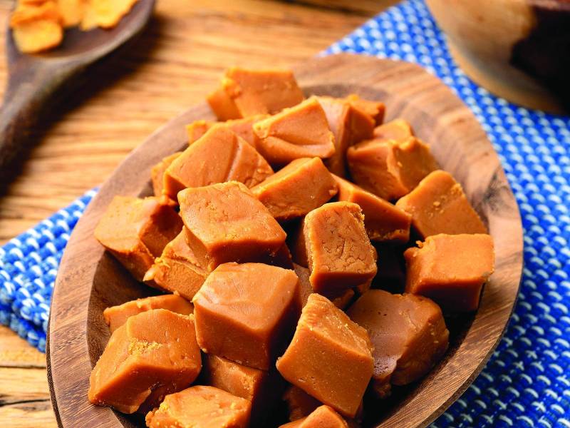 Doce de leite or dulce de leche, traditional south american milk candy with ingredients over wooden table.