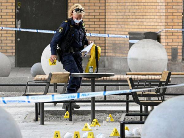 Un oficial forense de la policía trabaja en la escena de un tiroteo en el centro comercial Farsta en el sur de Estocolmo el 10 de junio de 2023.