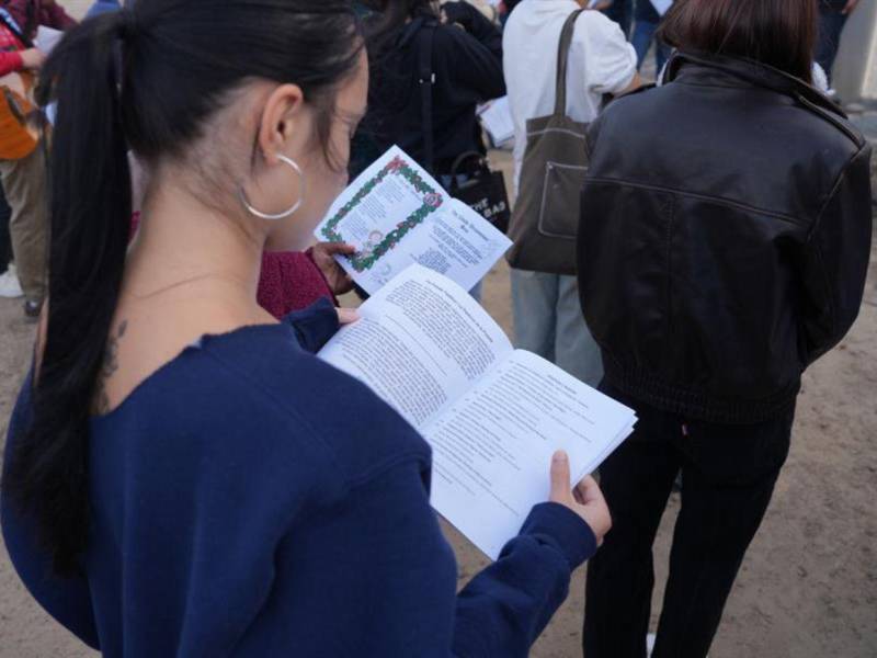 Una jovencita observa un folleto de los cantos durante su participación en la ‘Posada sin Fronteras’, la tradición de escenificar el viaje a Belén.