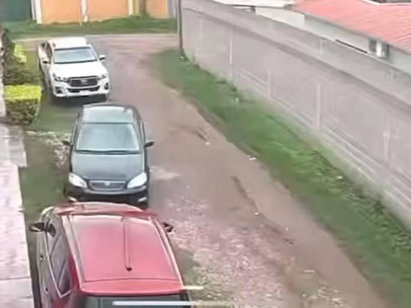 El secuestro fallido de un empresario de Juticalpa quedó captado en videos de las cámaras de seguridad, en donde se ve los tres minutos de angustia que pasó el hondureño. A continuación cuadro a cuadro de lo qué sucedió. El hecho delictivo inició cuando un vehículo turismo, negro, llegó a la calle de la víctima y se estacionó entre un pick-up blanco frente a la casa de la víctima y una camioneta roja, el conductor sospechoso se situó a manera de tener una fácil salida para huir.