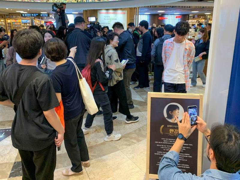 Clientes en la librería principal de la cadena Kyobo, en el distrito de Jongno en Seúl, se agolpan para hacerse con copias de libros de la escritora Han Kang.