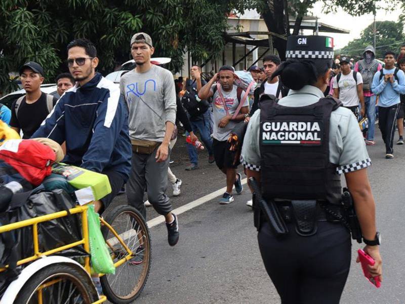 Una integrante de la Guardia Nacional resguarda una caravana de migrantes que caminan hacia la frontera con Estados Unidos en Tapachula, Chiapas, México.