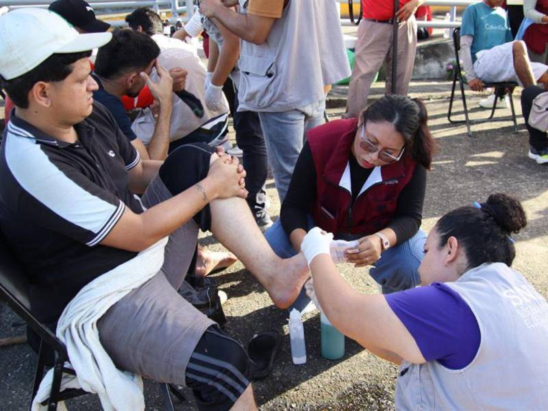 Un médico atiende a un migrante durante la más reciente caravana que salió del sur de México, en el municipio de Huixtla. Sus pies llagados por tanto caminar le obligaron a hacer una pausa en el camino.