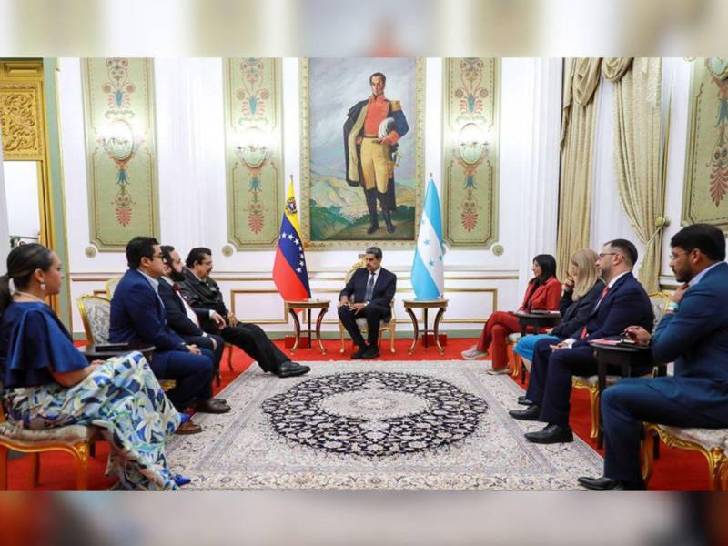 Representantes de Honduras y Venezuela durante la reunión en el Palacio de Miraflores, frente a un cuadro de Simón Bolívar.