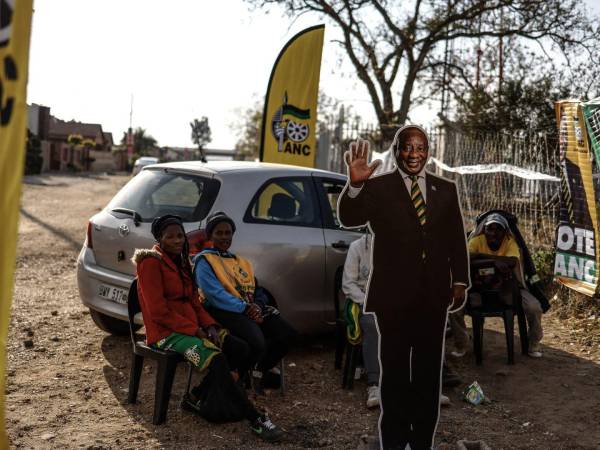 Miembros del partido Congreso Nacional Africano con una imagen del Presidente Ramaphosa de Sudáfrica en mayo.