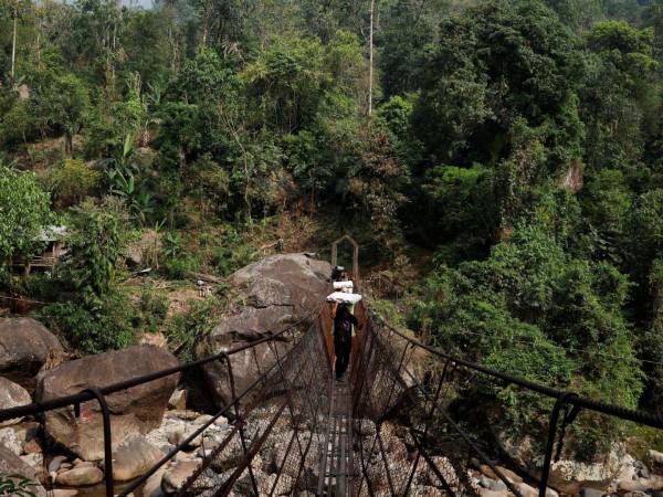 Trabajadores transportan máquinas de votación electrónica a un colegio electoral remoto en el Estado indio de Meghalaya recientemente.