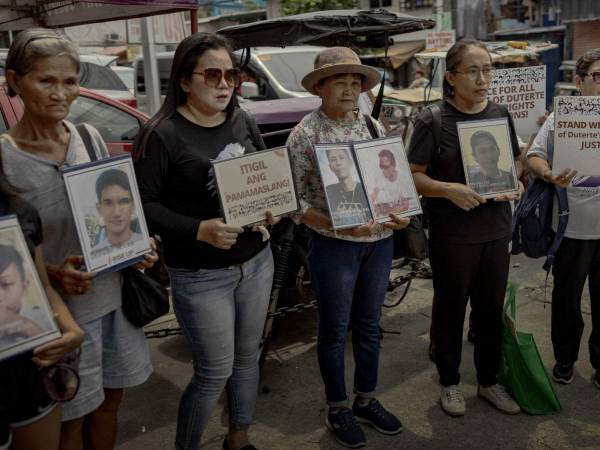 Familiares de víctimas de la guerra antidrogas frente a un tribunal en Caloocan, Filipinas, donde se juzgó a policías. (Ezra Acayan para The New York Times)