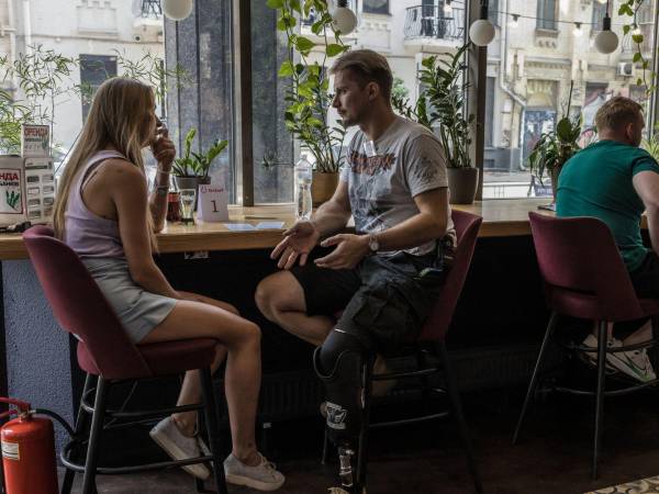 Serhii Chuikov, de 38 años, (segundo izq.) y Svitlana Kryvoruchko, de 36 años, (der.) en un evento de citas rápidas.