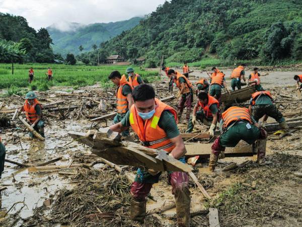 Revisando escombros en el lugar de un deslave en la provincia de Lao Cai en Vietnam, tras el tifón Yagi.