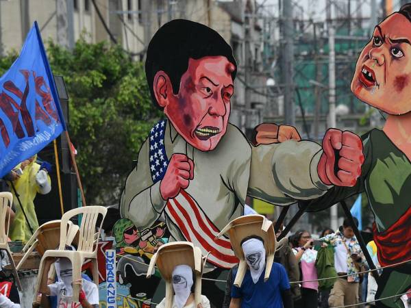 Manifestantes en Filipinas portan imágenes del Presidente Marcos y la Vicepresidenta Duterte en julio.