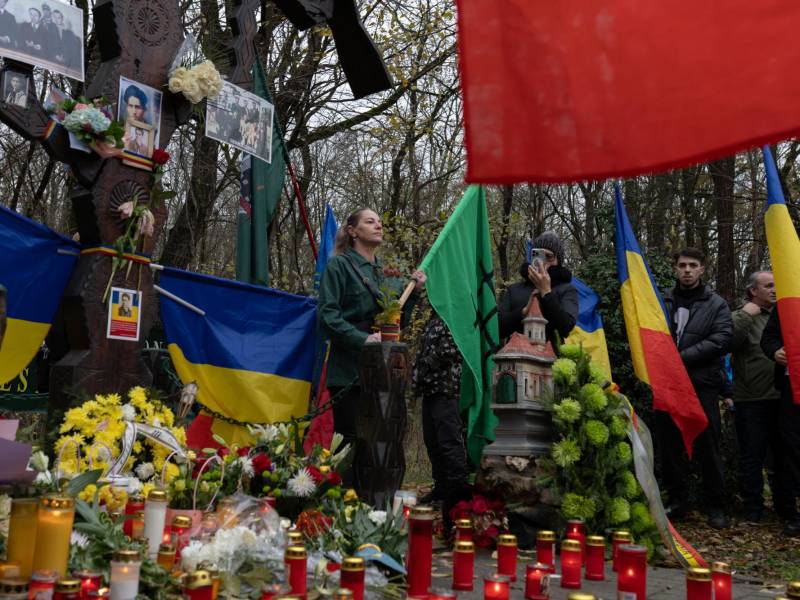 Una mujer con una bandera del antisemita Movimiento Legionario en honor de su fundador en un evento en Bucarest.