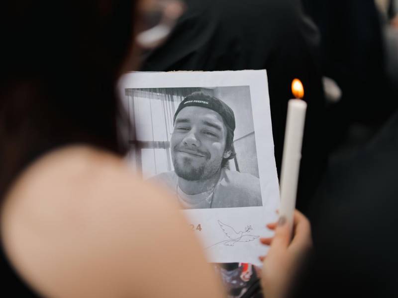 Una fanática sostiene una foto del cantante Liam Payne, durante un homenaje al artista en Buenos Aires, Argentina.