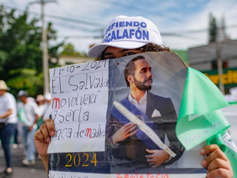 Una empleada pública sostiene un cartel con la imagen de Nayib Bukele durante la marcha del 19 de octubre de 2024 para exigir sus derechos laborales.