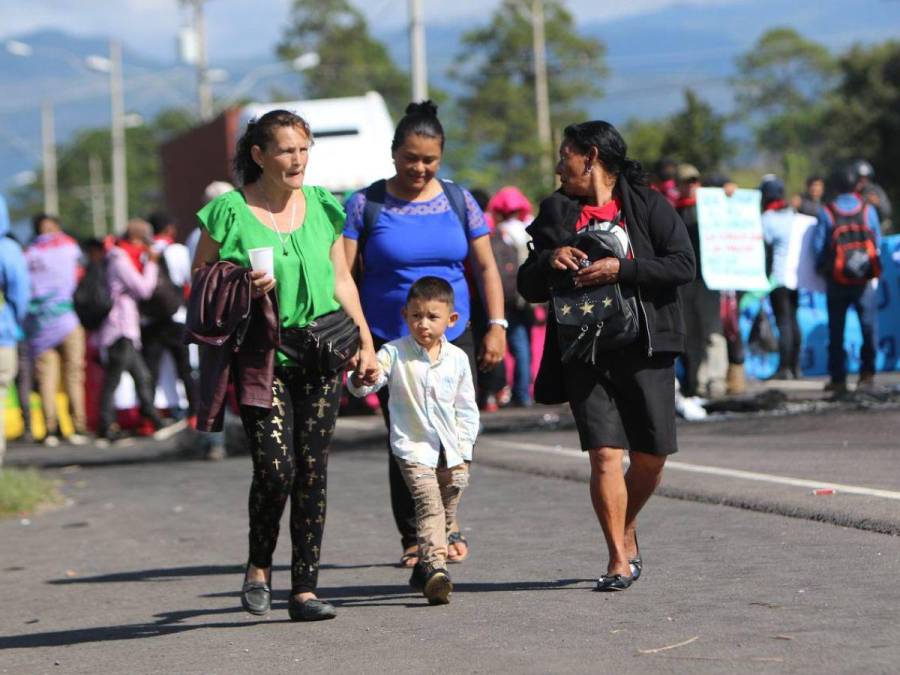 Con maleta en mano y niños en brazos, hondureños caminan por protesta en carretera CA-5